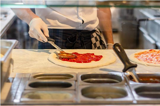 A chef is making a pizza